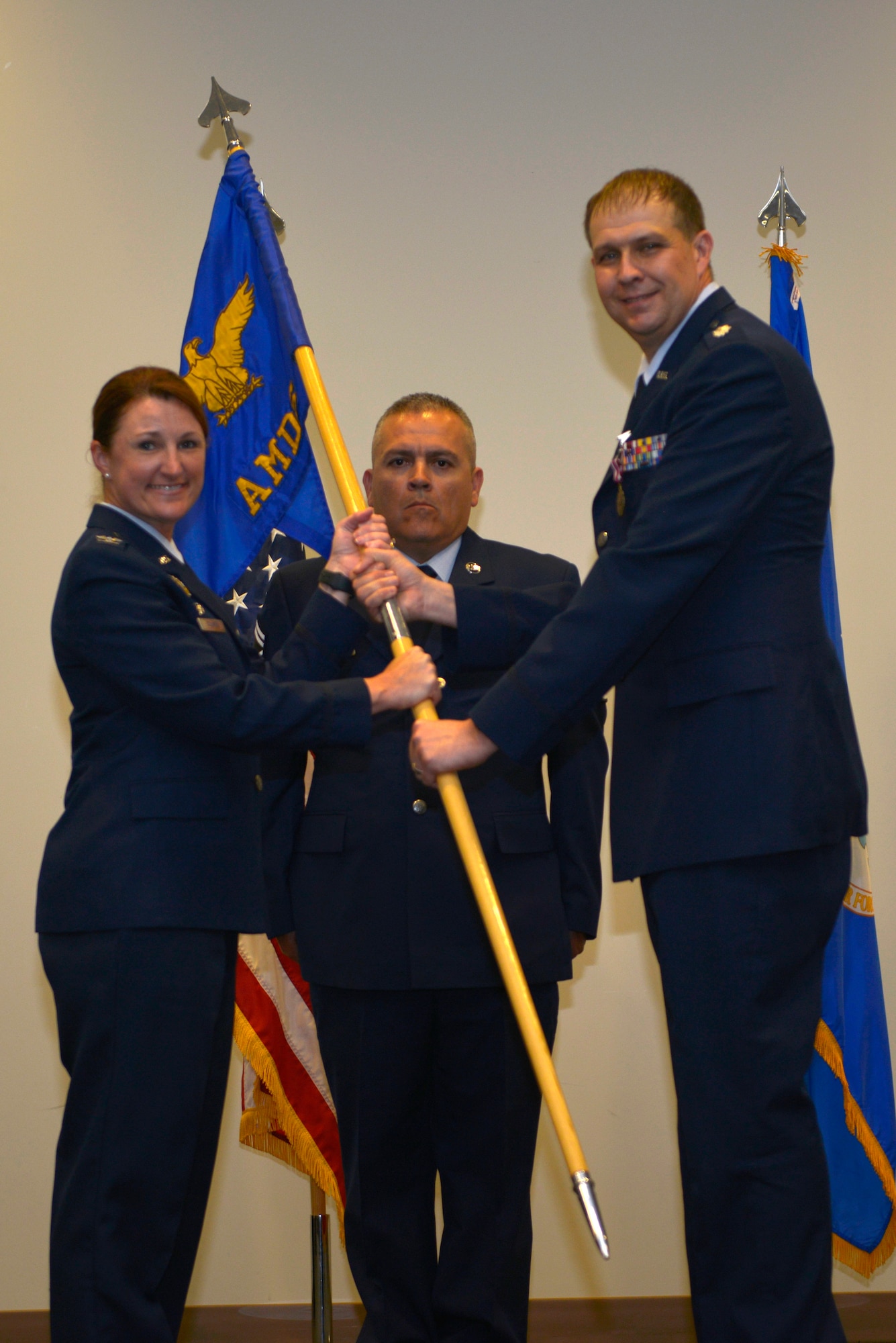 U.S. Air Force Col. Beatrice T. Dolihite, 81st Medical Group service commander, receives the 81st Aerospace Medicine Squadron guidon from Lt. Col. Michael A. Blowers, outgoing 81st AMDS commander, during the 81st AMDS change of command ceremony inside the Roberts Maintenance Facility at Keesler Air Force Base, Mississippi, June 4, 2019. The passing of the guidon is a ceremonial symbol of exchanging command from one commander to another. (U.S. Air Force photo by Airman Seth Haddix)