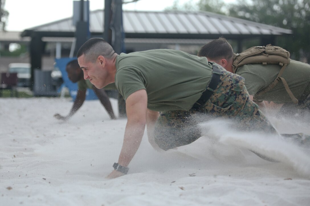 1st Sgt. Adrian Munoz low crawls through the sand during the "Throwdown at Fightertown" aboard Marine Corps Air Station Beaufort, May 31. Munoz is the company First Sergeant of Combat Logistics Company-23 aboard the air station.