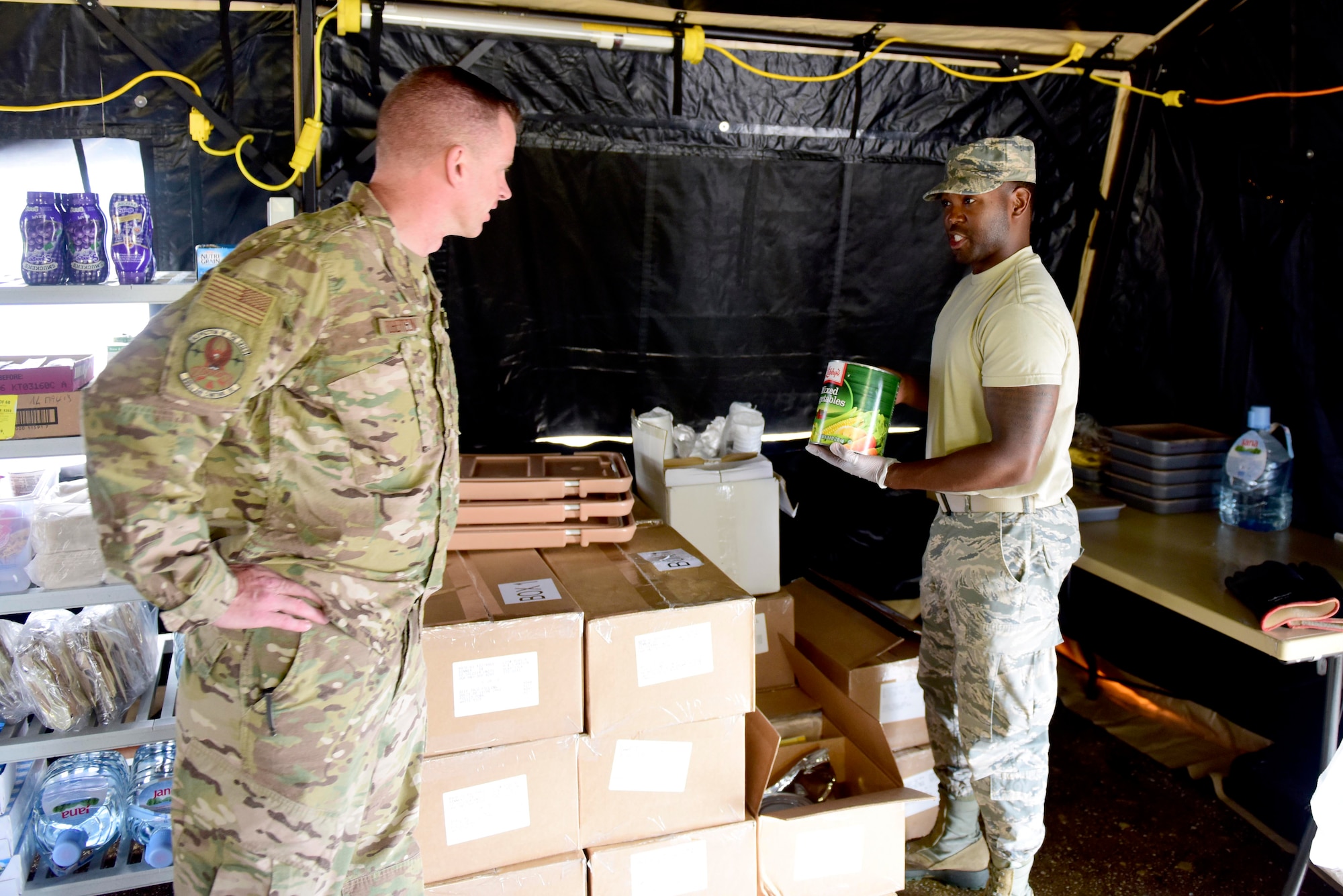 Airman 1st Class Jawan Dial, 31st Force Support Squadron assistant sports director, explains the contents of unitized group rations to Lt. Col. Brian Robertson, 606th Air Control Squadron commander, outside Pula, Croatia, May 28, 2019. The 31st FSS provided food services to the 606th ACS during exercise Astral Knight 19. (U.S. Air Force photo by Tech. Sgt. Tory Cusimano)