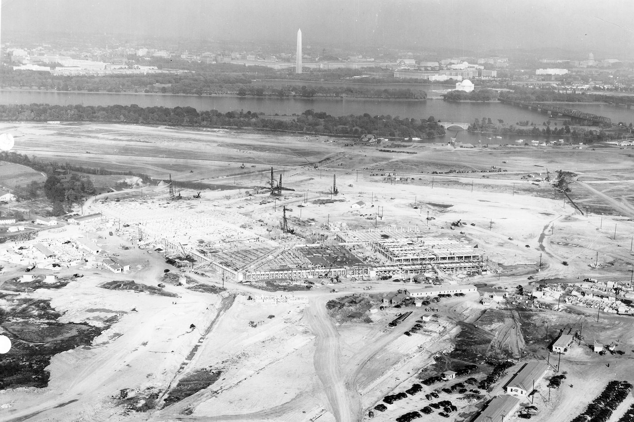 Construction begins on a massive plot of land. In the distance is the Washington Monument.