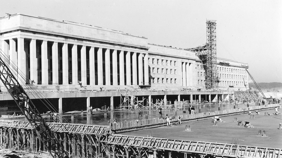 Scaffolding, a crane and construction crews surround a building that will eventually be the Pentagon.