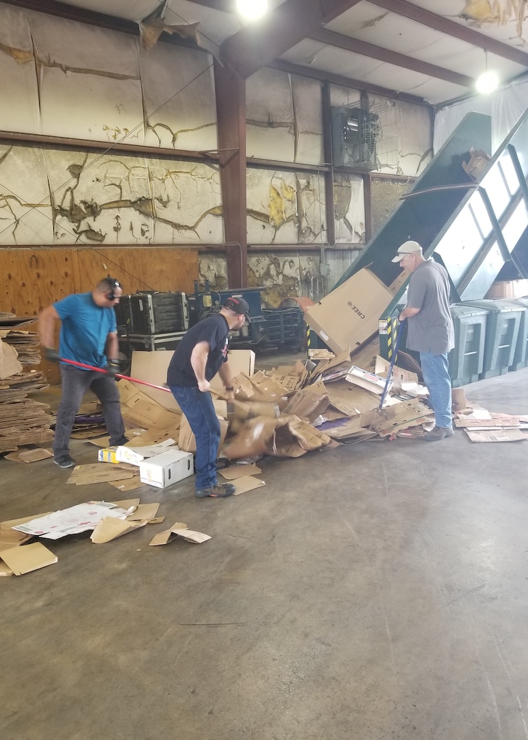 From left, Luis Alvarez, Scott Tauscher and Brian Martin, Joint Base San Antonio Qualified Recycling Program motor vehicle operators, prepare cardboard for baling at the JBSA-Lackland Recycling Center.