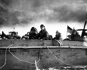 Troops and crewmen aboard a Coast Guard Landing Craft, Vehicle, Personnel (LCVP) approach Normandy beach on D-Day, June 6, 1944.