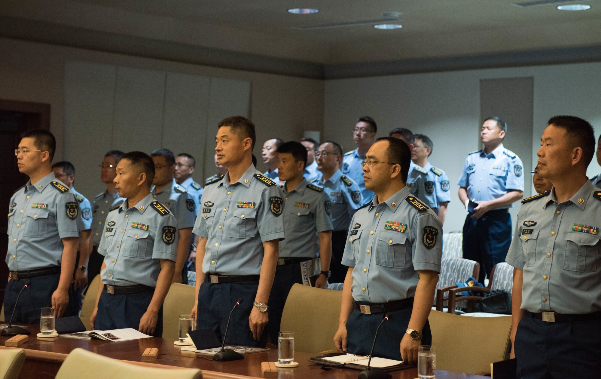 Members of the People’s Liberation Army Air Force Command College wait for PLAAF and U.S. Air Force leadership to enter the room during a visit to Headquarters Pacific Air Forces at Joint Base Pearl Harbor-Hickam, Hawaii, May 28, 2019.