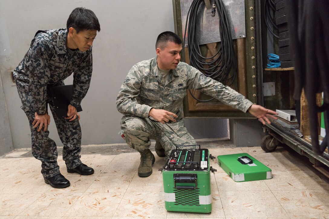 U.S. Air Force Airman 1st Class Miguel Bravo, nondestructive inspection journeyman assigned to the 18th Equipment Maintenance Squadron, demonstrates the use and function of the Lorad LPX-160 x-ray apparatus during a bilateral training exercise with the Japan Air Self-Defense Force May 23, 2019, on Kadena Air Base, Japan. This bilateral training exercise focused on teaching JASDF members the functions and purpose of aerospace ground equipment and nondestructive inspection flights. (U.S. Air Force photo by Airman 1st Class Cynthia Belío)