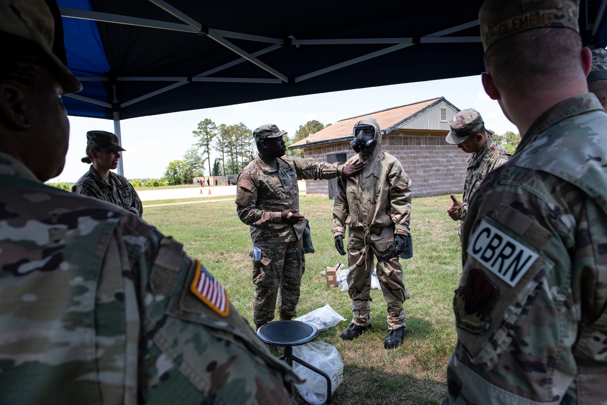 U.S. Army Sgt. Kwame Osei, U.S. Army Central Command chemical, biological, radiological and nuclear noncommissioned officer in charge, shows U.S. Soldiers and Airmen how to properly wear mission oriented protective posture gear at Shaw Air Force Base, S.C., May 22, 2019.