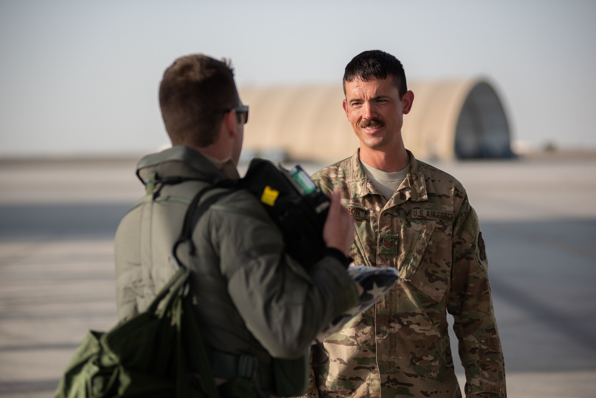 Tech. Sgt. Kenneth Peterson, 380th Expeditionary Aircraft Maintenance Squadron F-35A Lightning II crew chief, speaks to a 4th Expeditionary Fighter Squadron F-35 pilot, after handing him a flag June 6, 2019, at Al Dhafra Air Base, United Arab Emirates.