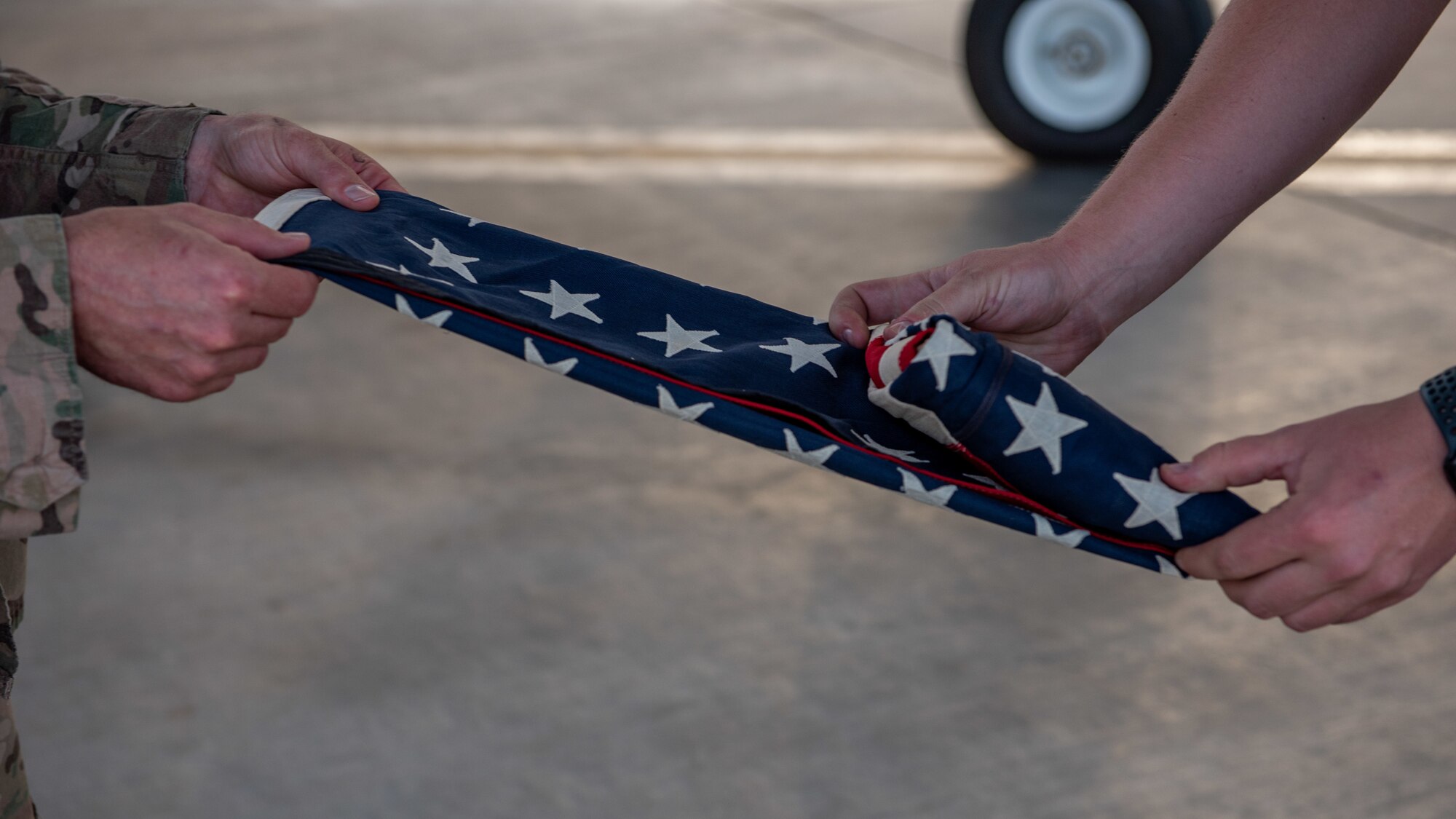 Tech. Sgt. Kenneth Peterson, left, and Senior Airman Quinton Bullock, 380th Expeditionary Aircraft Maintenance Squadron F-35A Lightning II crew chiefs, fold a 48-star flag June 6, 2019 at Al Dhafra Air Base, United Arab Emirates.