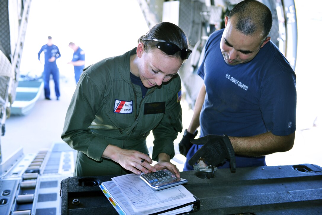 Petty Officer 3rd Class Brittany Willard, an aviation electronics technician from Coast Guard Air Station Sacramento, calculates the weight for approximately 3,000 pounds of gear loaded into the back of a C-27 Spartan aircraft at the air station, Aug. 28, 2017.