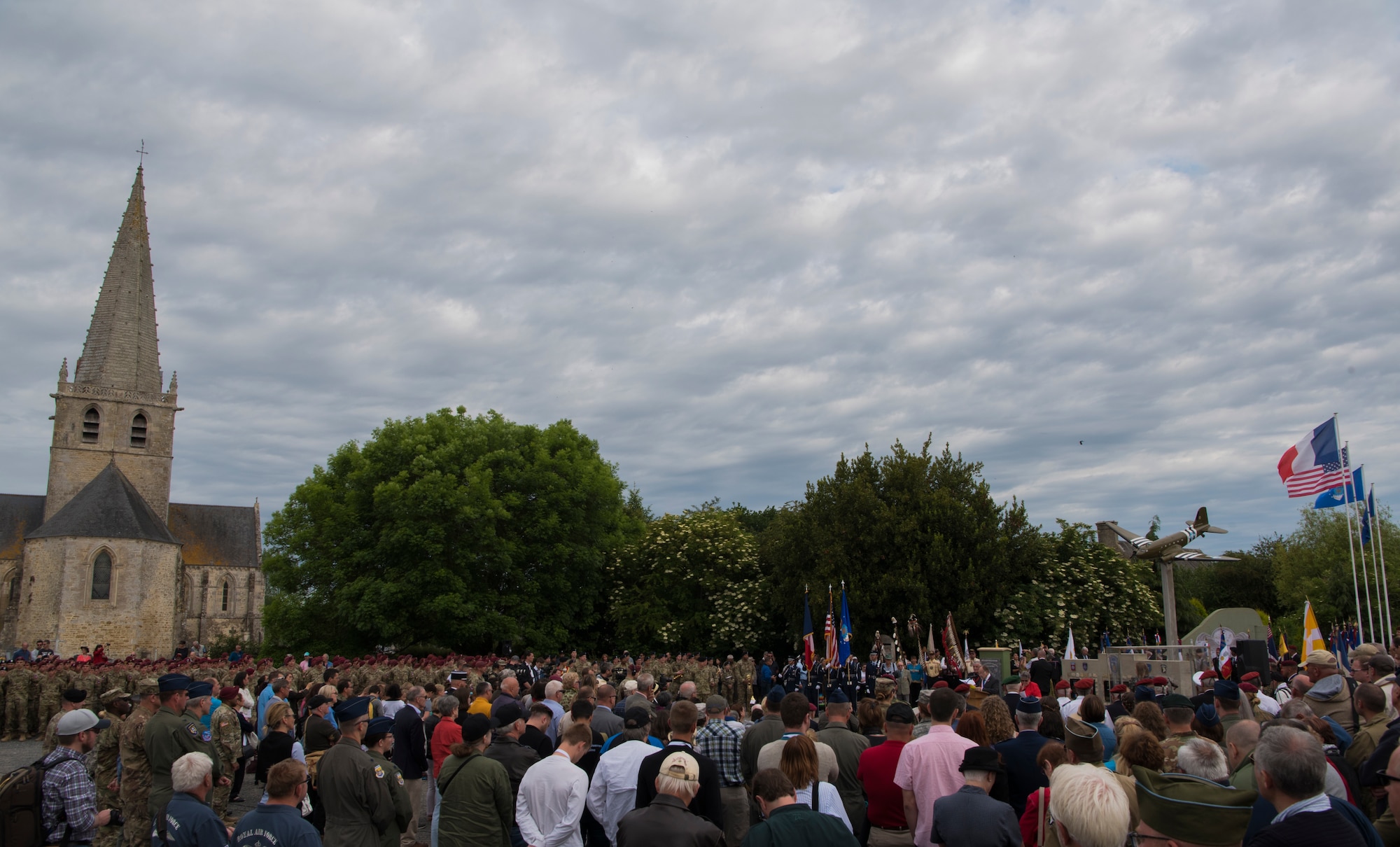 Hundreds of guests and active duty service members from the United States and Germany gather around the U.S. Air Force monument near the Eglise Saint-Candide de Picauville church for a ceremony honoring all airborne troops and flight crew that served on D-Day in Picauville, France, June 4, 2019. The ceremony was one of 55 ceremonies held between June 1 - 9 in honor of the 75th anniversary of D-Day. (U.S. Air Force photo by Senior Airman Kristof J. Rixmann)