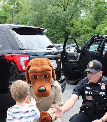 McGruff and Officer Perkins, NSA Police, greet a young visitor at the Armed Forces & National Police Celebration.