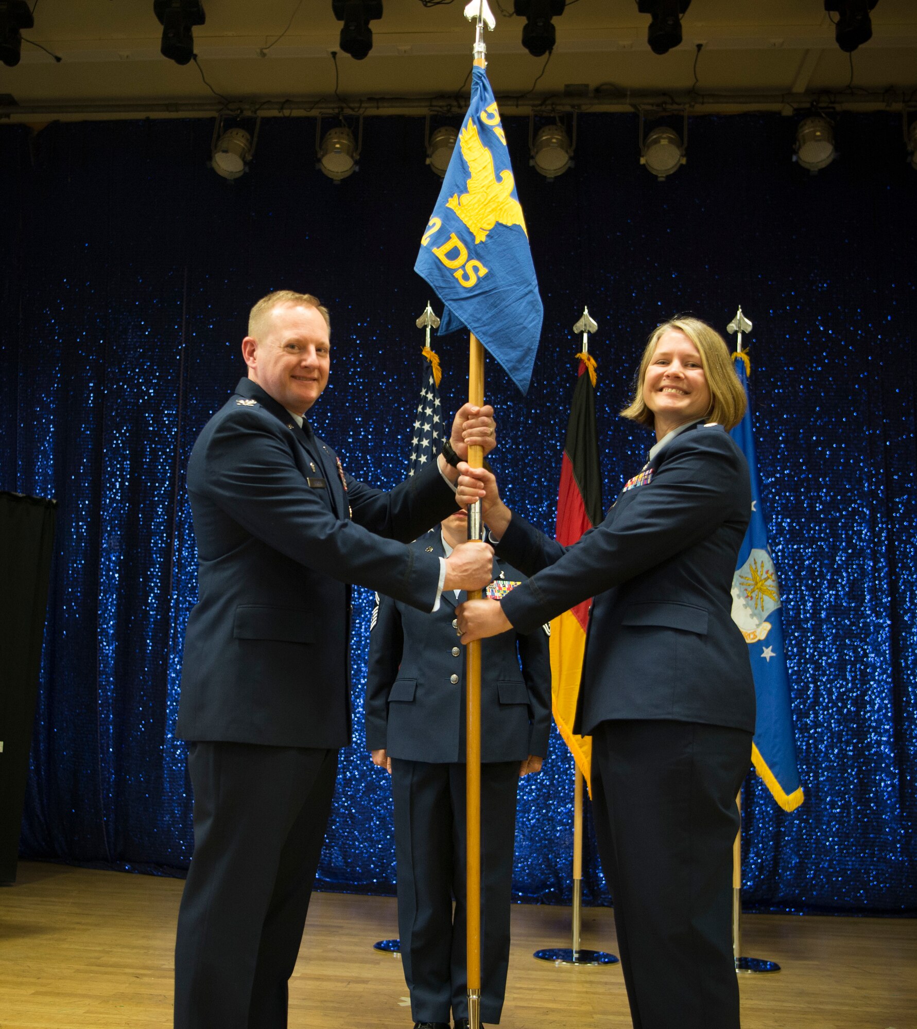 U.S. Air Force Col. Edward Lagrou, 52nd Medical Group commander, left, gives the ceremonial guidon to U.S. Air Force Lt. Col. Elizabeth Bowman, incoming 52nd Dental Squadron commander, right, during the 52nd DS change of command ceremony at Spangdahlem Air Base, Germany, June 6, 2019.
