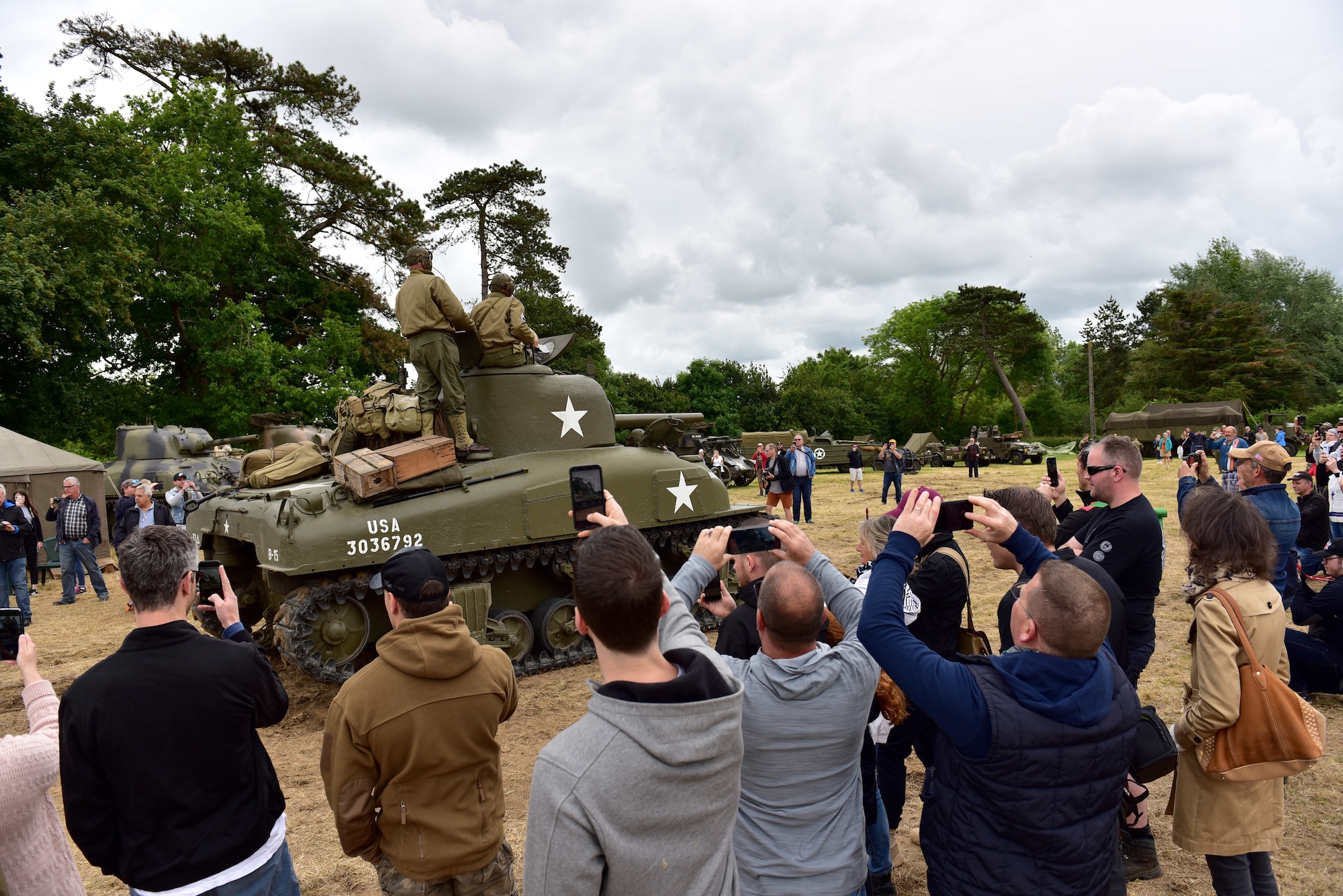 A tank drives by a crowd