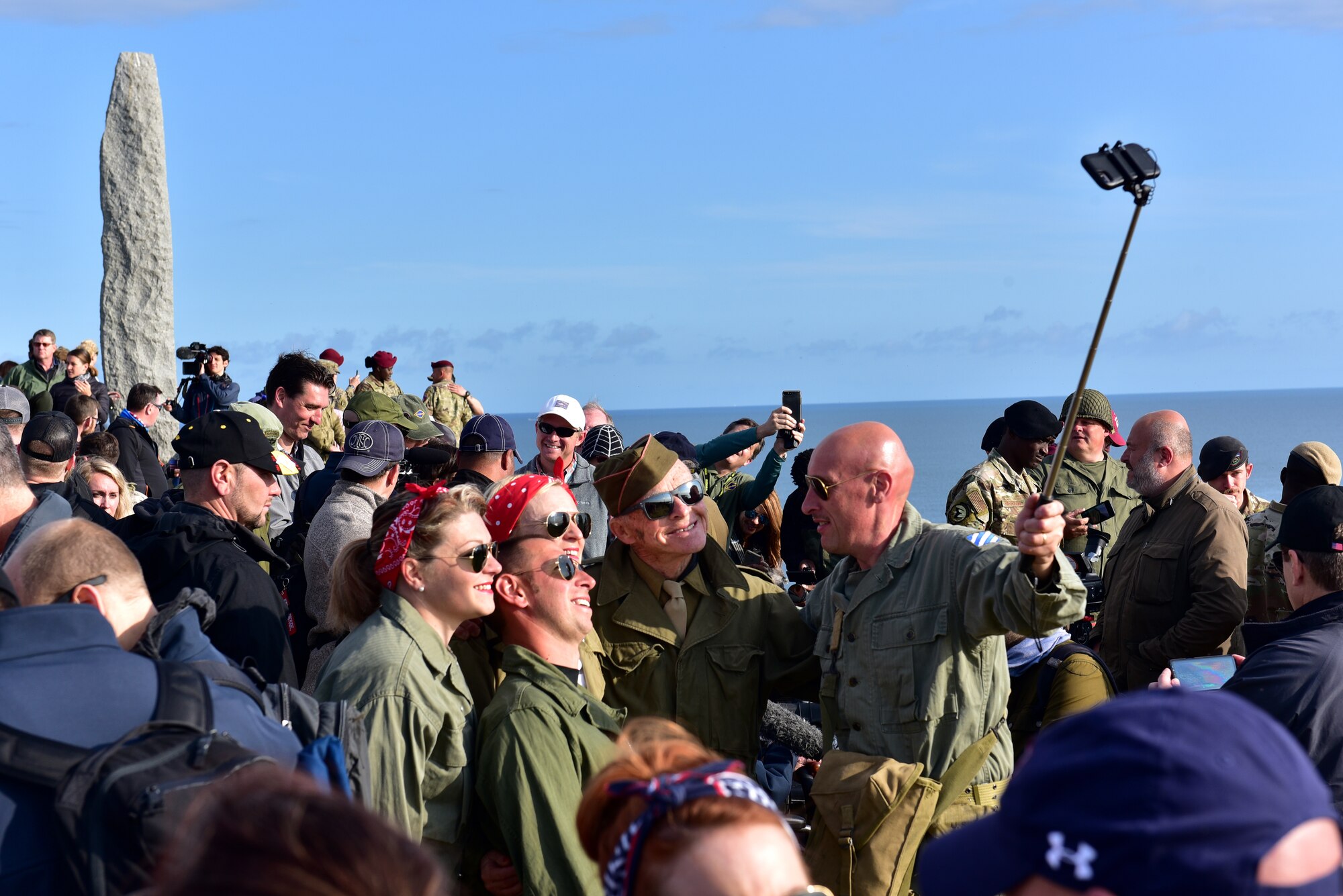 A C-130J flies over a crowd