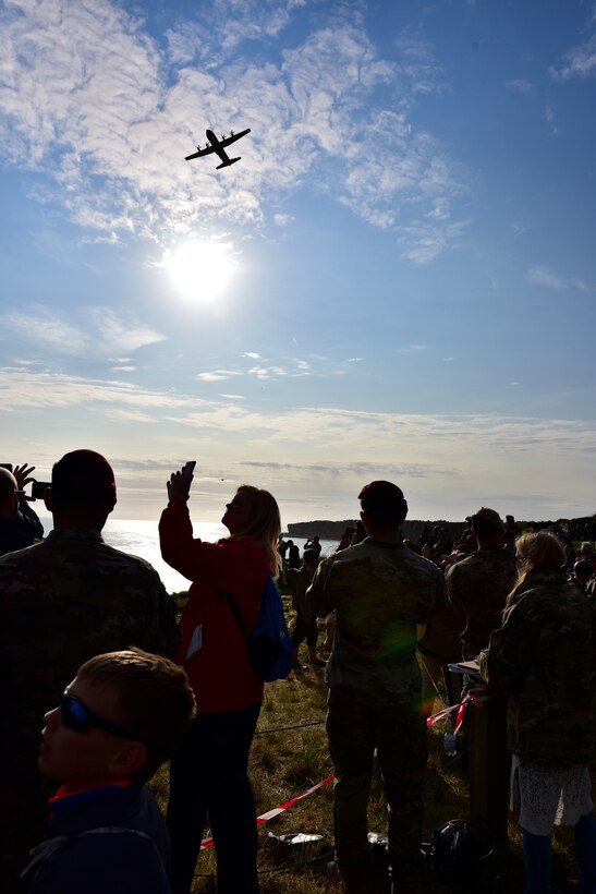 A C-130J flies over a crowd