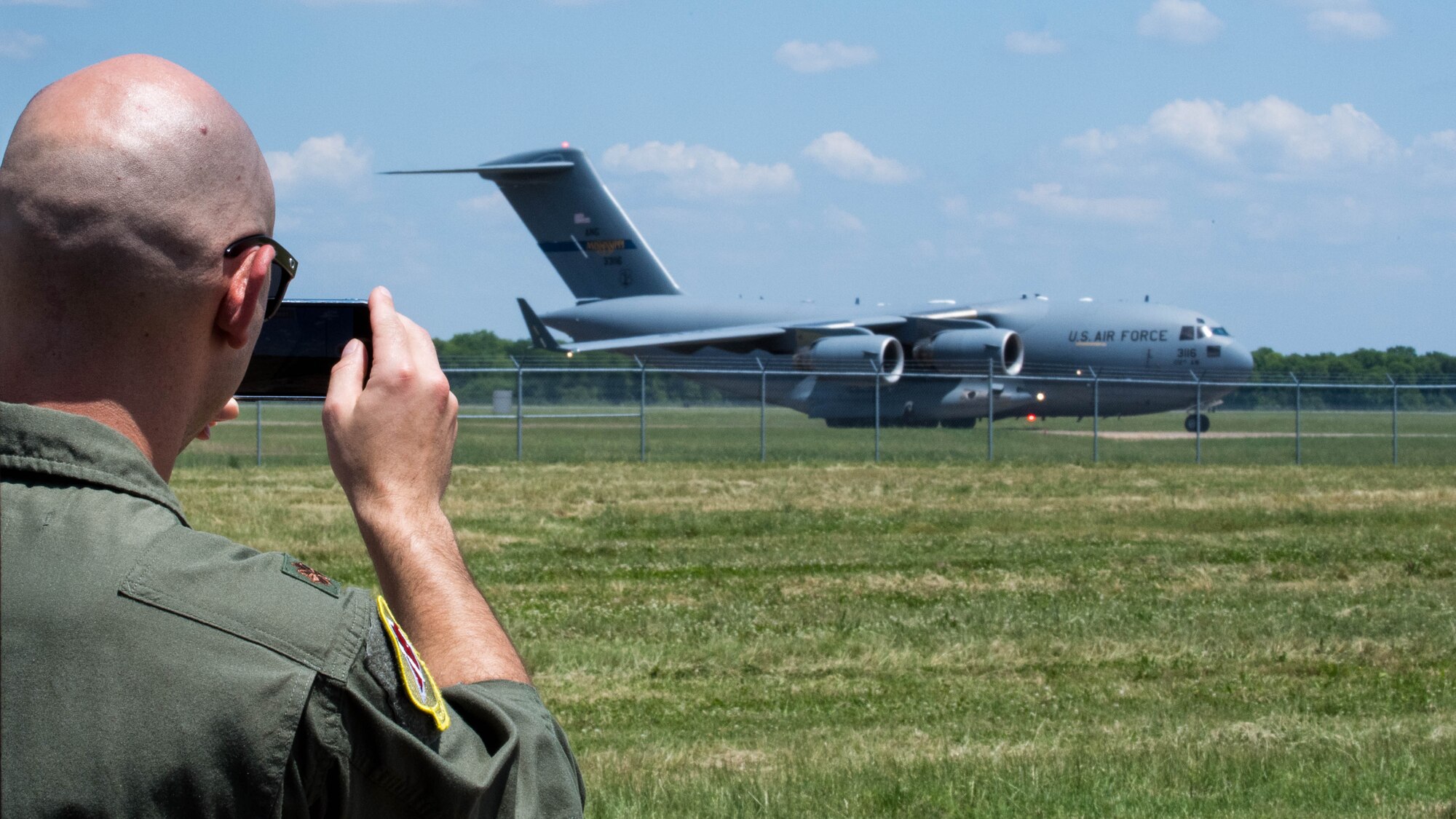 Maj. John R. Blankenship, a B-52 Stratofortress pilot with the 96th Bomb Squadron, records his wife Maj. Natasha E. Blankenship, a C-17 Globemaster III pilot with the 183rd Airlift Squadron in Jackson, Mississippi, as she lands a C-17 as apart of the Barksdale Defenders of Liberty Air Show at Barksdale Air Force Base, La., May 16, 2019. The Blankenships met each other during pilots training and have been married for the past eight years. (U.S. Air Force photo by Airman Jacob B. Wrightsman)
