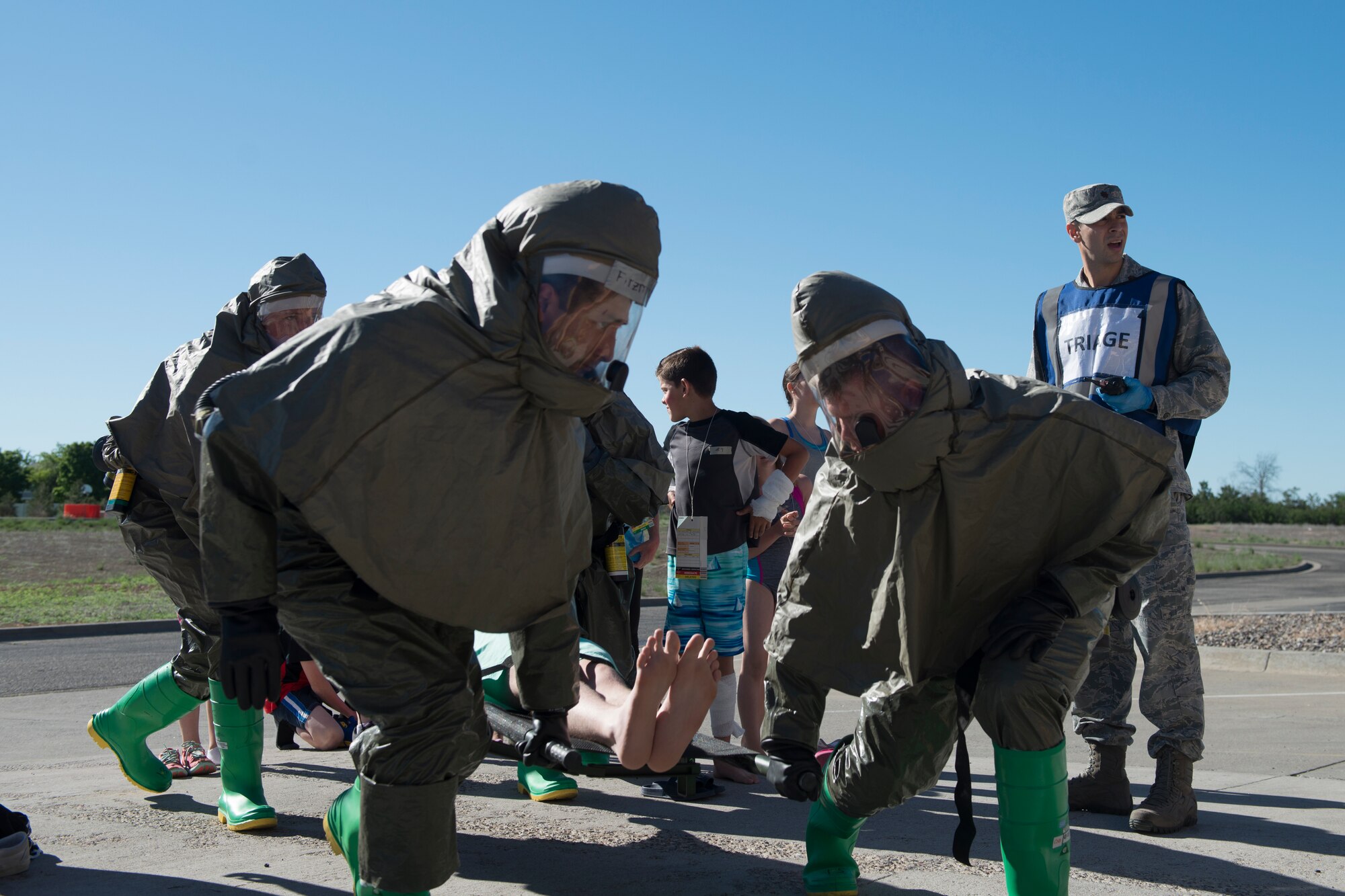 366th Aerospace Medicine Squadron bioenvironmental engineering Airmen carry a child to a decontamination tent, June 5, 2019, at Mountain Home Air Force Base, Idaho. The 366th Medical Treatment Facility conducted a decontamination exercise to simulate real world contingencies. (U.S. Air Force photo by Airman 1st Class JaNae Capuno)
