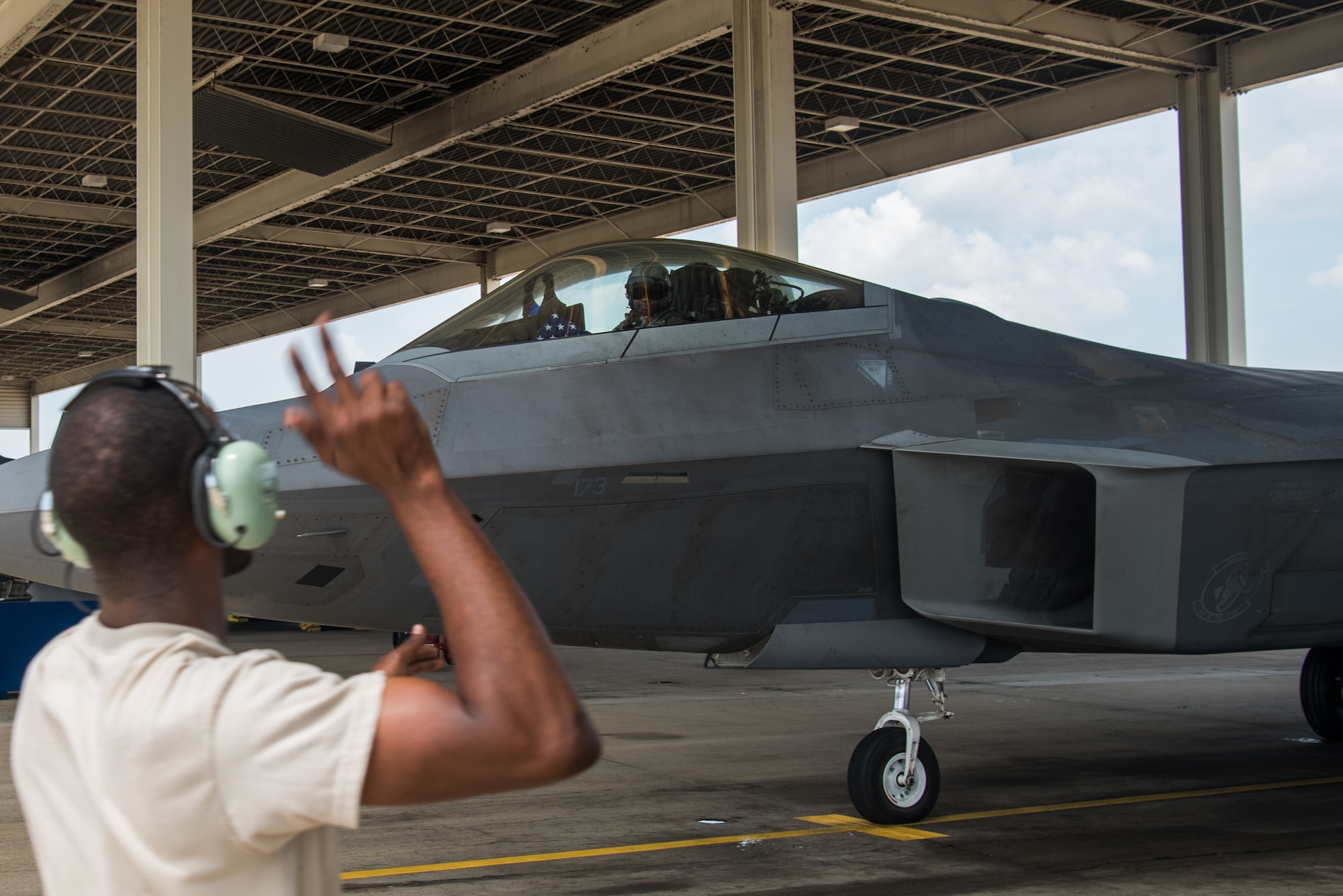 An F-22 Maintainer marshals U.S. Air Force Maj. Paul “Loco” Lopez, F-22 Raptor Demonstration Team pilot, before takeoff at Joint Base Langley-Eustis, Virginia, June 6, 2019.