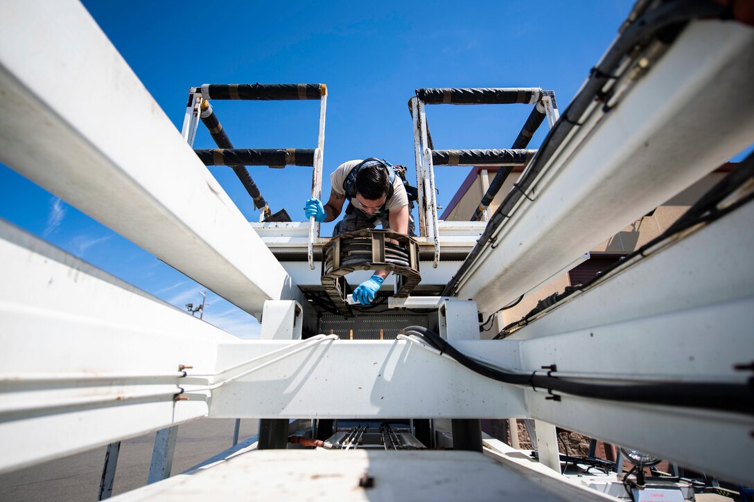 An airman works on a lift.