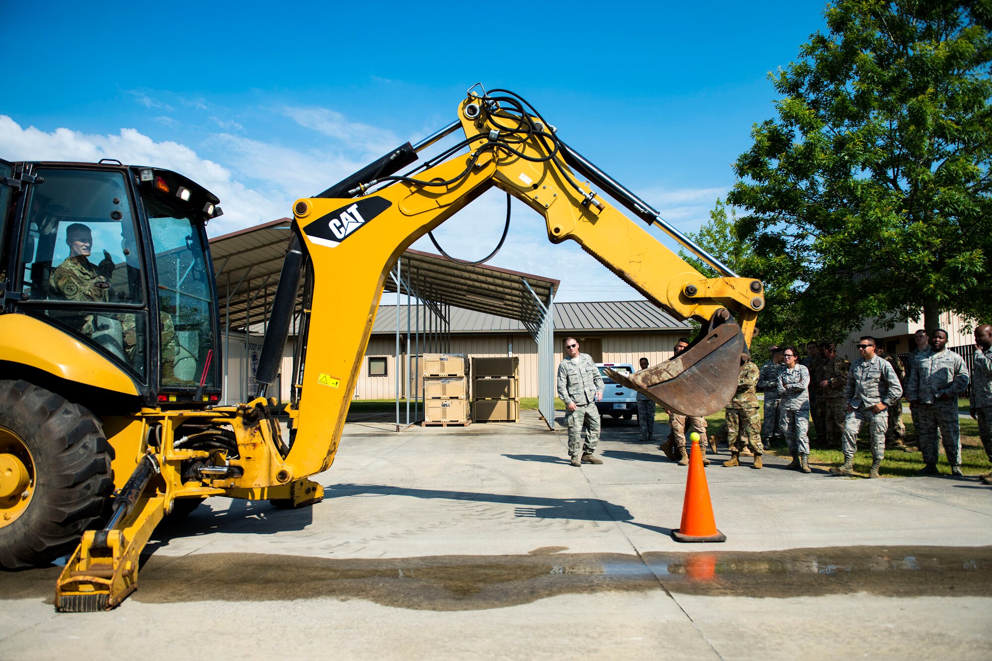 Col. Dee Jay Katzer, command engineer for Air Combat Command, operates a back hoe during a cone touch challenge during a squadron tour, May 22, 2019, at Moody Air Force Base, Ga. The challenge involved Katzer having to pick up a ball from the cone with a back hoe and then placing it back on the cone without it dropping. Katzer’s first visit to Moody consisted of a base tour, along with visiting various 23d Civil Engineer Squadron (CES) shops. He also observed Airmen from the 23d CES conduct airfield recovery training. (U.S. Air Force photo by Senior Airman Erick Requadt)