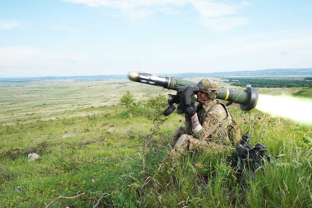 A soldier fires a missile in a field.