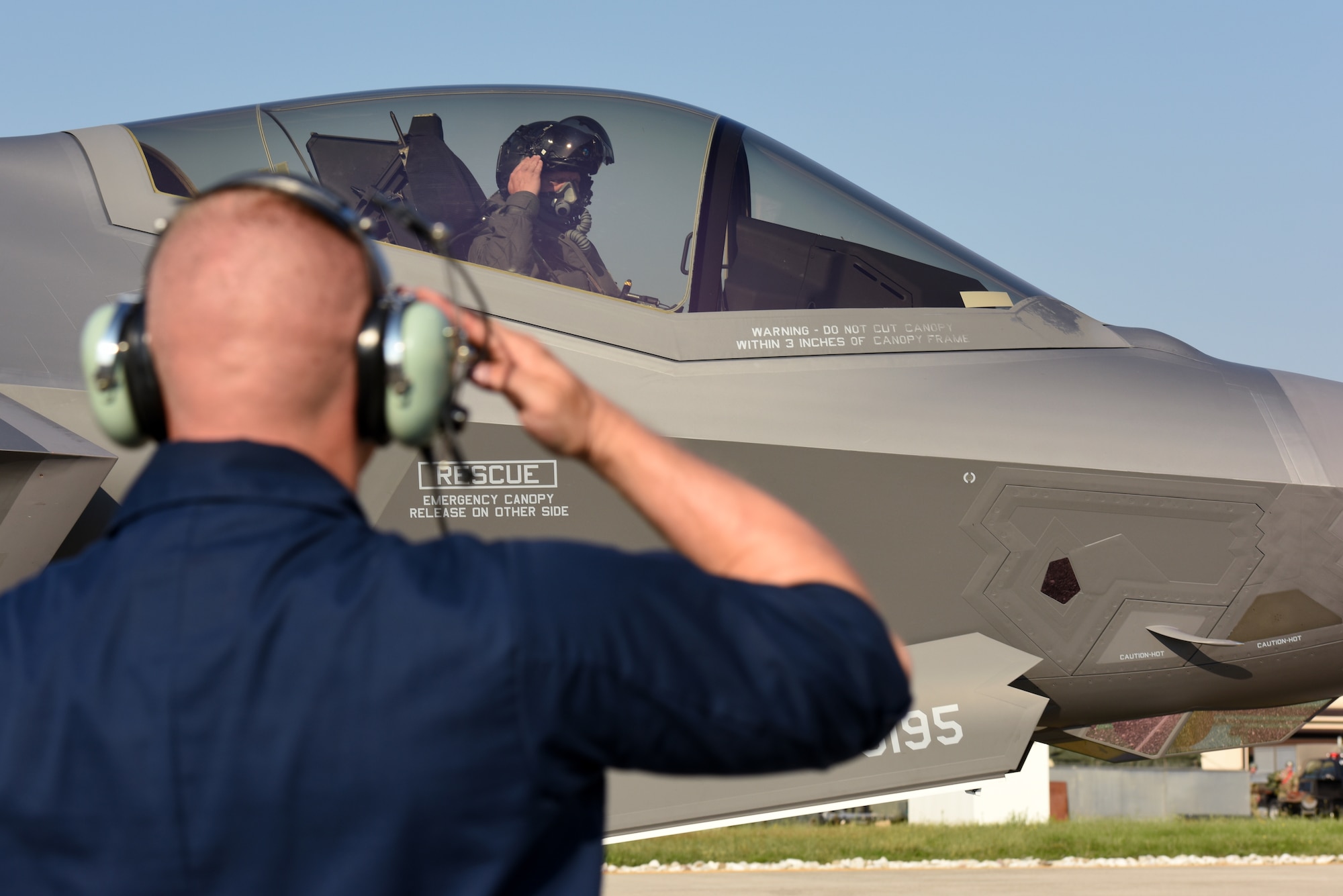 Senior Airman Christopher Kuhn, 421st Aircraft Maintenance Unit crew chief, salutes Lt. Col. Max Cover, 421st Fighter Squadron F-35A Lightning II fighter pilot, during Astral Knight 2019 on June 3, 2019, at Aviano Air Base, Italy. The F-35s are participating in Astral Knight 2019, a multinational integrated air and missile defense exercise that enhances relationships with allies and improves overall coordination with partner militaries during times of crisis. The Airmen are deployed from the active duty 388th and Reserve 419th Fighter Wings at Hill Air Force Base, Utah. (U.S. Air Force photo by Tech. Sgt. Jim Araos)