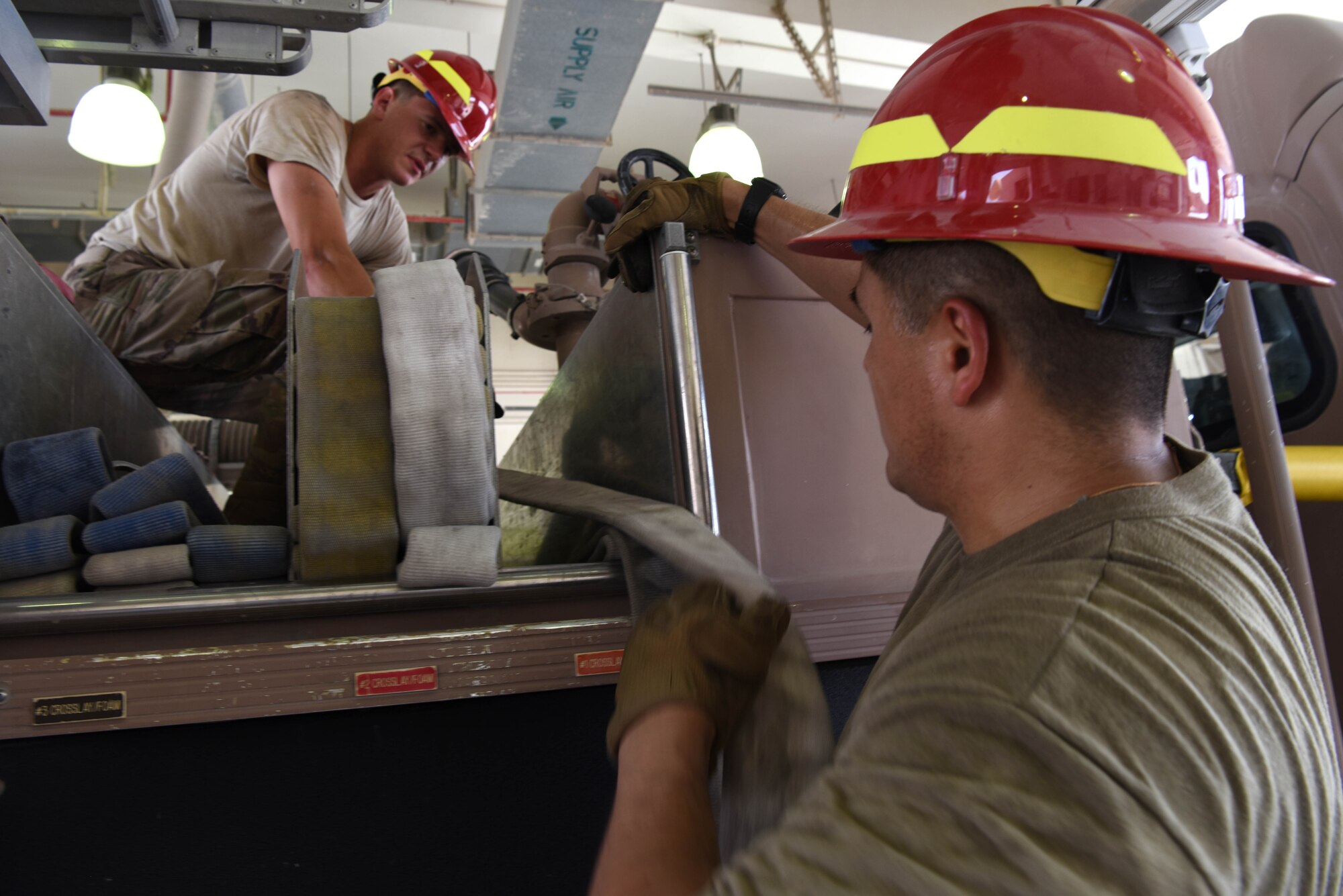 Airman 1st Class Samuel Olombo, 379th Expeditionary Civil Engineer Squadron firefighter and, Tech. Sgt. Eduardo Castro 379th ECES station captain store their equipment after training on June 6, 2019, at Al Udeid Air Base, Qatar. In addition to fire and emergency services, the 379th ECES also provide premier fire and emergency services and host robust fire prevention and education program.  (U.S. Air Force photo by Staff Sgt. Ashley L. Gardner)