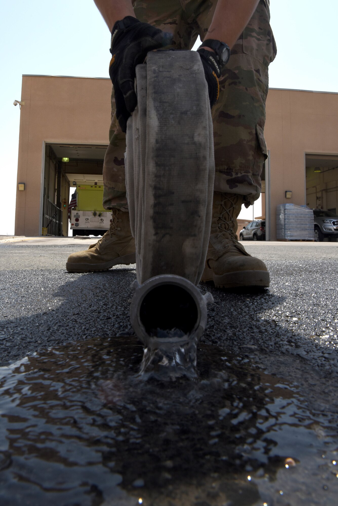 Staff Sgt. John Huaman, 379th Expeditionary Civil Engineer Squadron engine operator rolls up a fire hose on June 6, 2019, at Al Udeid Air Base, Qatar. The 100-foot hand line is broken into 50-foot lengths and is drained and rolled after each use. (U.S. Air Force photo by Staff Sgt. Ashley L. Gardner)