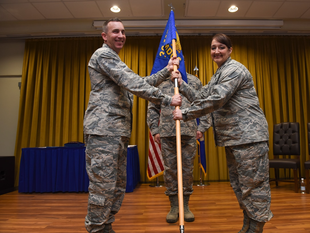 Col. Christopher Estridge, 39th Medical Group commander, left, passes the guidon to Lt. Col. Dana Adrian, 39th Medical Operations Squadron incoming commander, during the change of command ceremony June 7, 2019, at Incirlik Air Base, Turkey. The change of command is a military tradition held to allow all of the units to witness the formal change of authority. (U.S. Air Force photo by Staff Sgt. Matthew J. Wisher)
