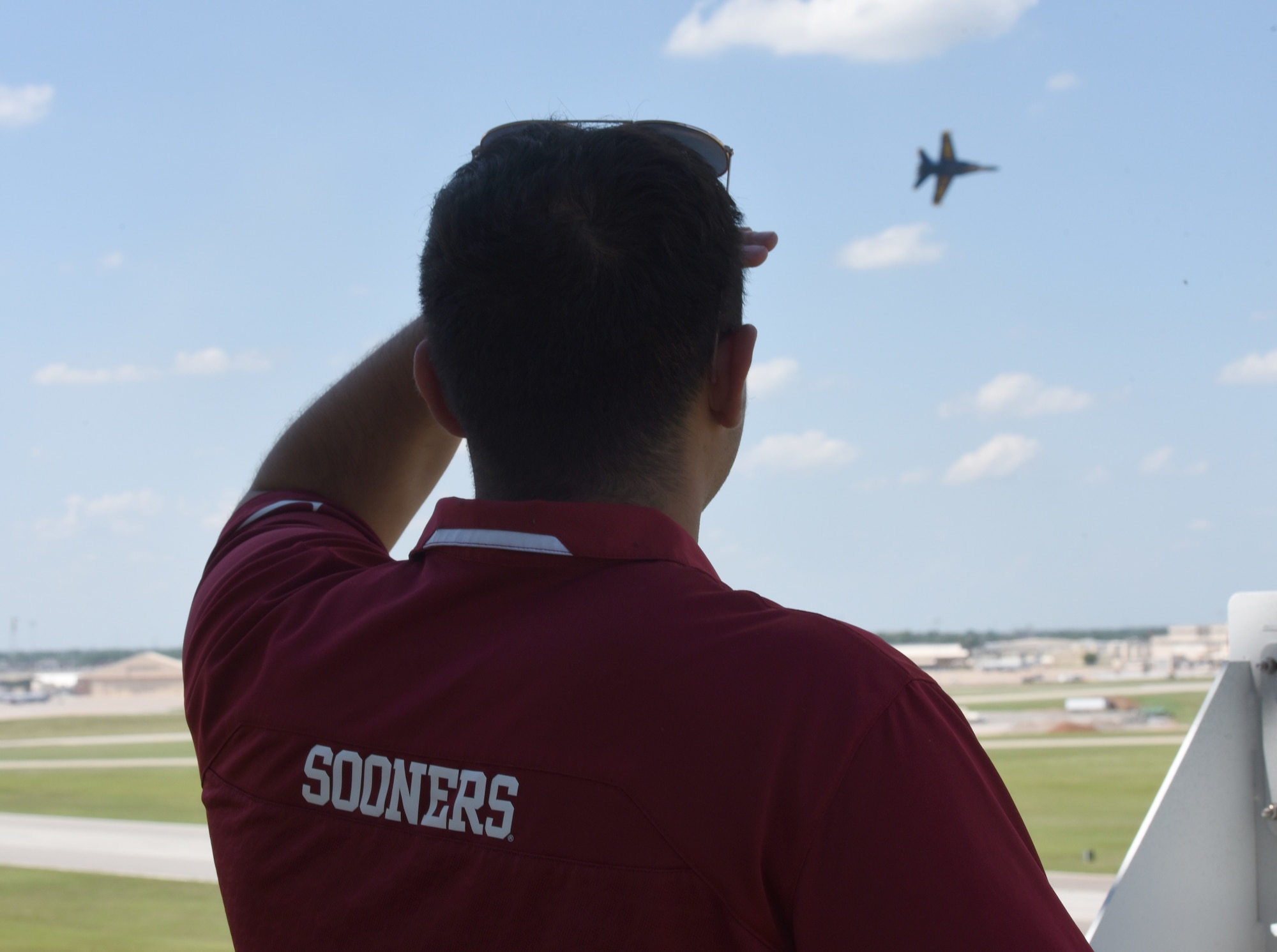 Tinker Take Off staff writer Jacob McGuire watches from Tinker Air Force Base air traffic control tower as an F/A-18 Hornet from the Blue Angels flight demonstration team flies by at one of their demonstrations for the bi-annual Star Spangled Salute Air & Space Show. (U.S. Air Force photo/Kelly White)