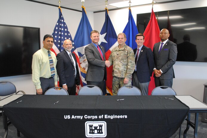 U.S. Army Corps of Engineers Col. Lars Zetterstrom shakes hands with Russ Poppe, executive director of the Harris County Flood Control District, following the signing of a new Project Partnership Agreement for the design and construction of the Clear Creek Federal Flood Risk Management Project. The $295-million project will substantially reduce flood risks for a large portion of the Clear Creek watershed in Harris County, Brazoria County and Galveston County.

Pictured left to right: Shakhar Misir, project manager USACE
Galveston District, Gary Zika, federal projects department manager HCFCD, Russ Poppe, executive director HCFCD, Col. Lars Zetterstrom, commander USACE Galveston District, Ian Hudson, project manager HDFCD, Byron Williams, chief of Project Management Division at USACE Galveston District.