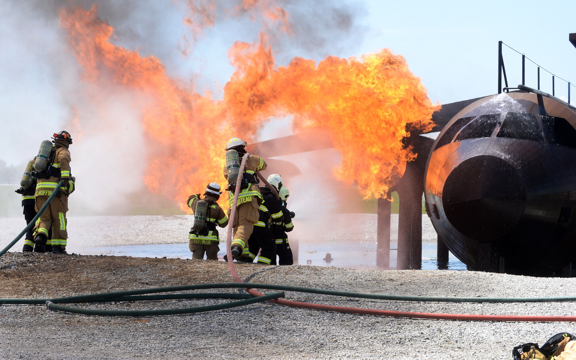 Ryan Hoffman, Offutt fire station chief, leads a group of firefighters from the Czech Republic air force, the 155th Air Refueling Wing, Nebraska Air National Guard and the Offutt fire department while instructing them on how to put out fire on a RC-135 aircraft during a live-fire training exercise at Offutt Air Force Base, Nebraska, June 5, 2019. The Nebraska Air National Guard works in association with the Czech Republic through the State Partnership Program. Each participating guard unit has a brother or sister unit assigned to them.