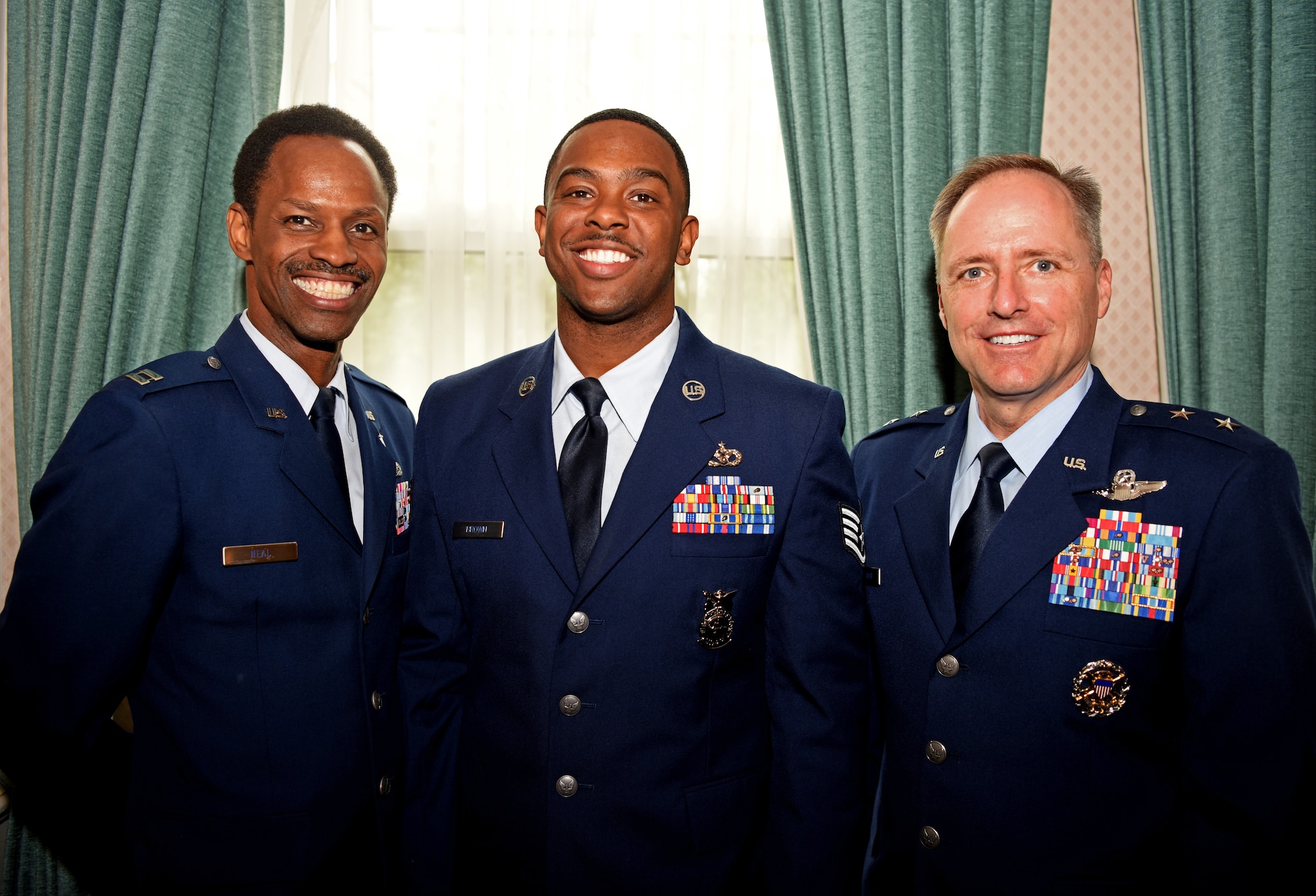 U.S. Air Force Capt. Kennie Neal, 100th Air Refueling Wing chaplain, Staff Sgt. Dajuantaye Brown, 100th Civil Engineer Squadron crew chief, and Maj. Gen. John Wood, Third Air Force commander, pose for a photo during a visit to RAF Mildenhall, England, May 31, 2019. Wood spent time during his visit to discuss leadership and acknowledge the hard work the Airmen of the 100th ARW displays each day. (U.S. Air Force photo by Airman 1st Class Brandon Esau)