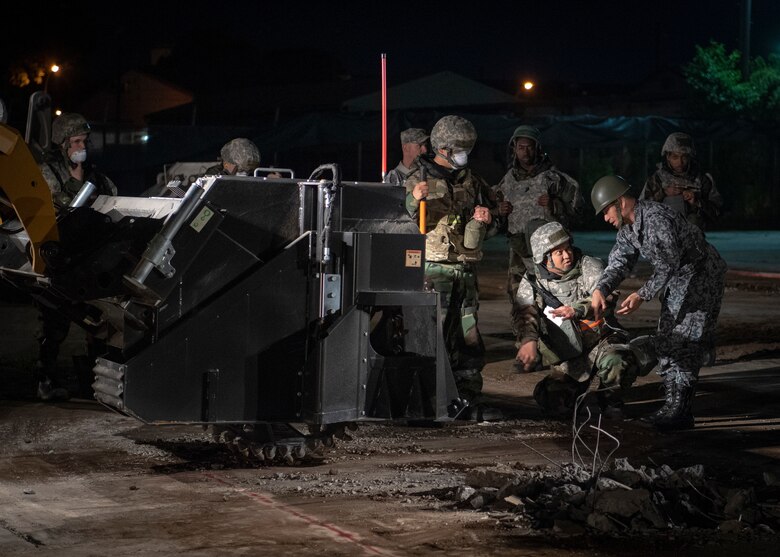 Airmen train Japan Air Self-Defense Force members on the process of cutting concrete slab as part of Rapid Airfield Damage Repair practice