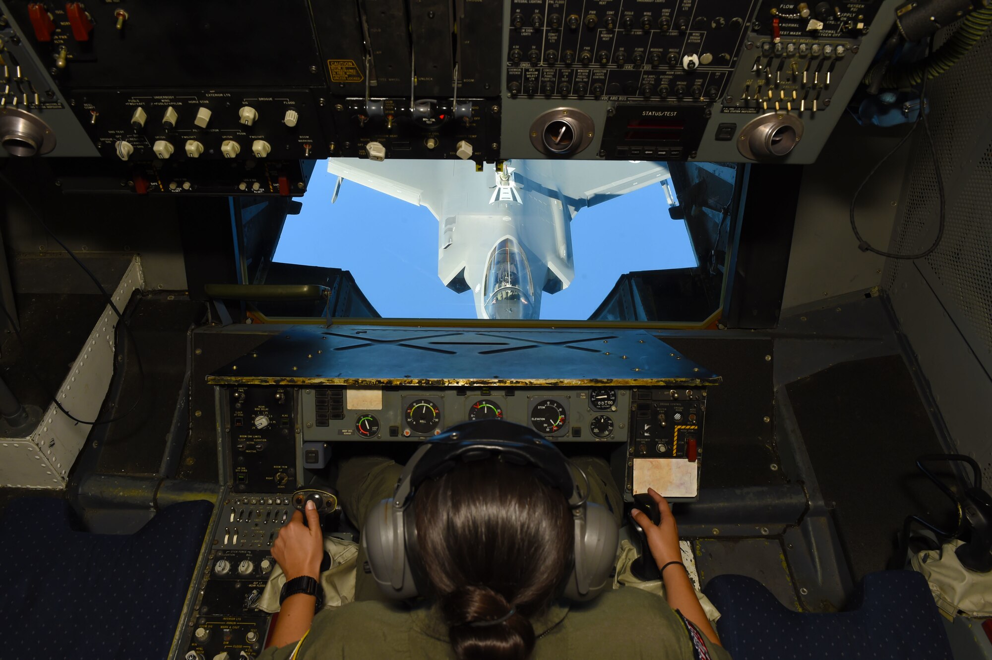 An Airman operates the fuel injection arm of a KC-10 Extender connected to an F-35 Lightning II