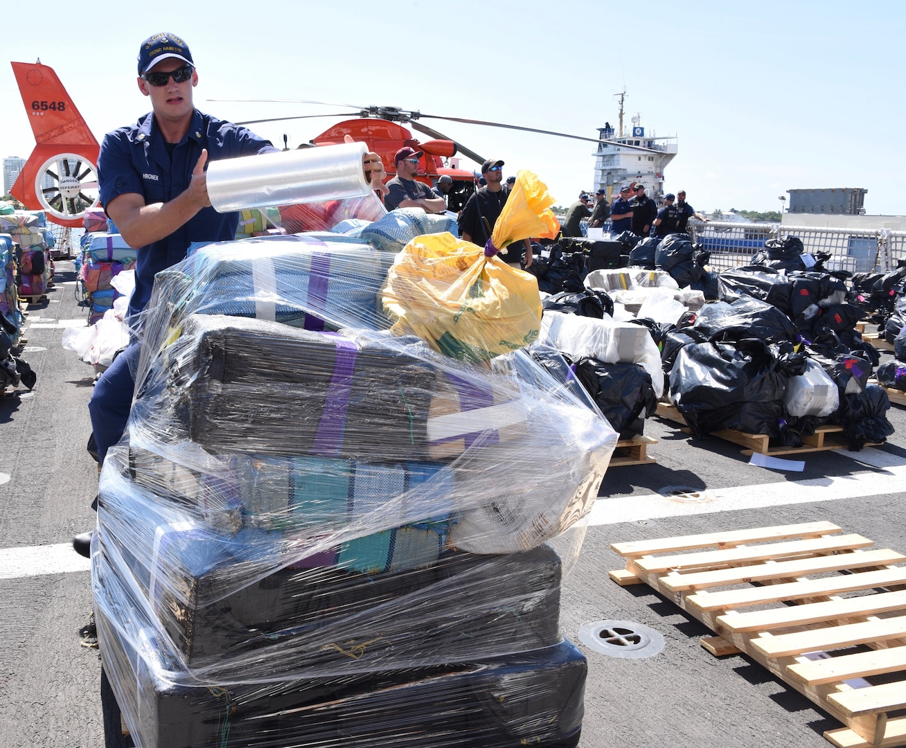 A Coast Guard Cutter Hamilton (WMSL-753) crewmember prepares a palette of interdicted cocaine.