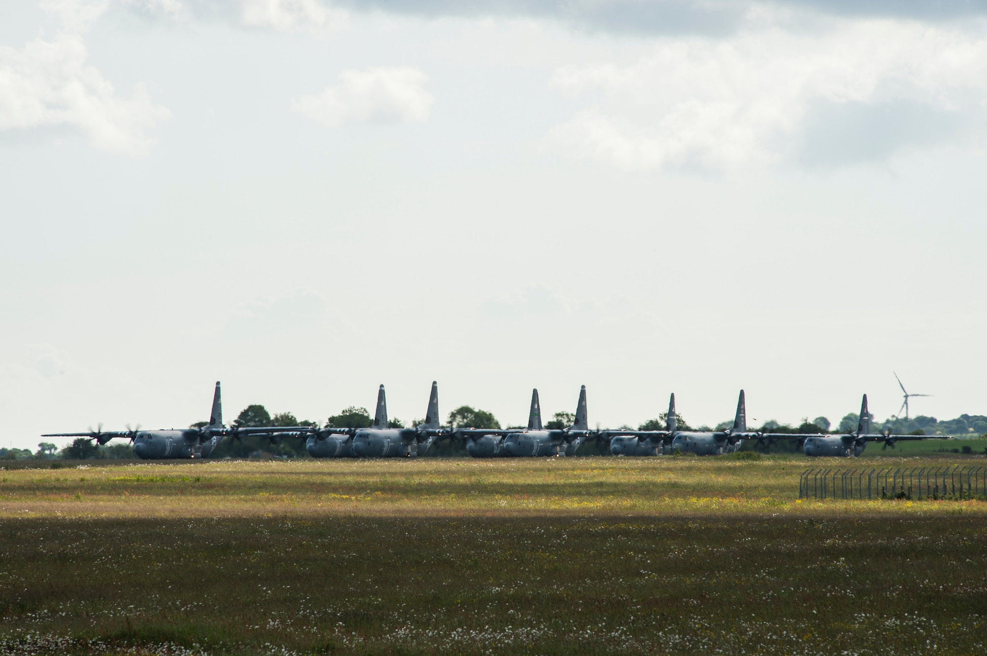 An eight-ship formation of U.S. Air Force C-130J Super Hercules stages on the runway of Cherbourg-Maupertus Airport, France, June 6, 2019. The aircraft are assigned to the 37th Airlift Squadron, 39th AS, 41st AS, 61st AS, and 62nd AS. The 37th, 61st, and 62nd are legacy squadrons of Troop Carrier Squadrons who conducted personnel drops during Operation Neptune June 6, 1944. (U.S. Air Force photo by Senior Airman Devin M. Rumbaugh)