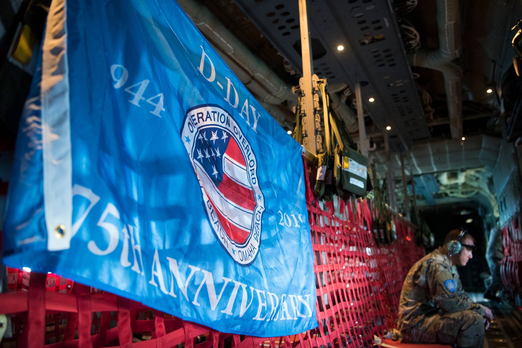 A U.S. Air Force service member sits on-board a C-130J Super Hercules during an eight-ship flyover of the Normandy-American Cemetery and Memorial in Colleville-sur-Mer, France, June 6, 2019. 2019 signifies the 75th anniversary of D-Day, June 6, 1944, where tens of thousands of Allied service members stormed the beaches of Normandy, beginning the liberation of France and Europe. (U.S. Air Force photo by Senior Airman Kristof J. Rixmann)