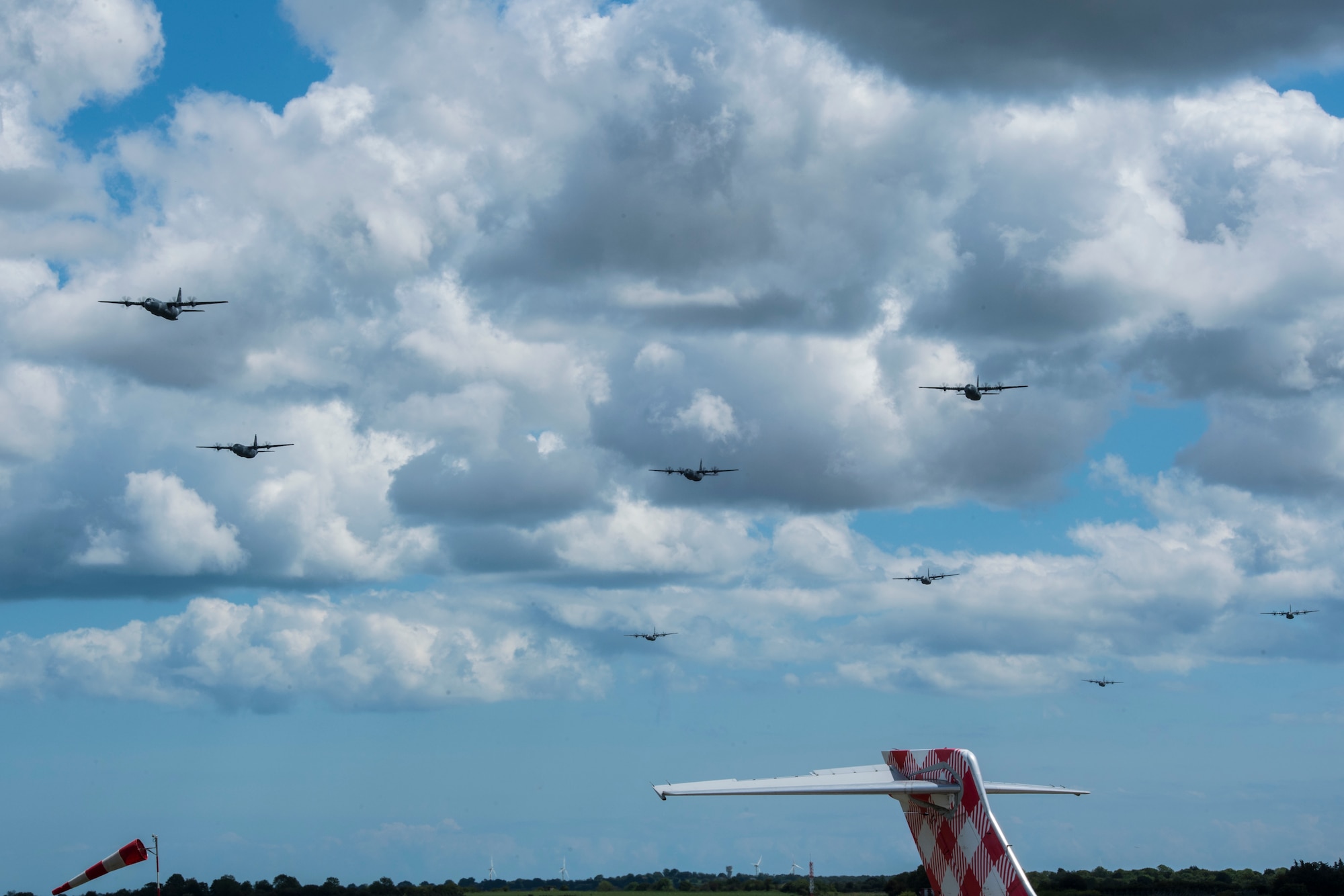 An eight-ship formation of U.S. Air Force C-130J Super Hercules flies over Cherbourg-Maupertus Airport, France, June 6, 2019. The formation flew over the D-Day commemoration ceremony held at the Normandy American Cemetery and Memorial. (U.S. Air Force photo by Senior Airman Devin M. Rumbaugh)