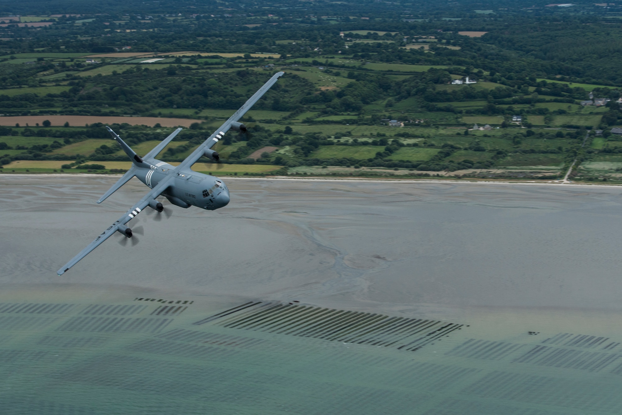 A U.S. Air Force C-130J Super Hercules, assigned to the 37th Airlift Squadron, Ramstein Air Base, Germany, wears the marks of “Whiskey 7,” as it flies over Utah Beach, Normandy, France, June 6, 2019. The 37th AS’ lineage draws from the 37th Troop Carrier Squadron, who wore the “Whiskey 7,” or W7 on their aircraft when they conducted paratrooper drops over Normandy, France during Operation Neptune, June 6, 1944. (U.S. Air Force photo by Senior Airman Devin M. Rumbaugh)