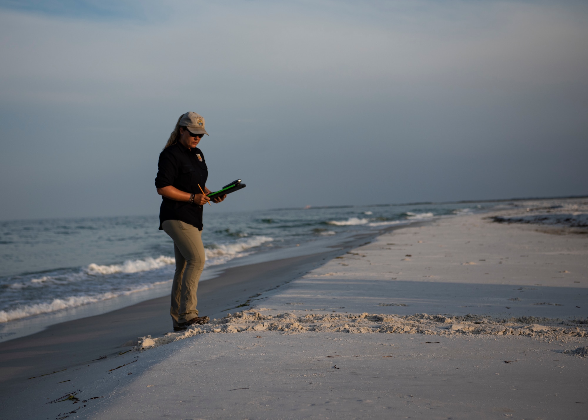 Danielle Bumgardner, U.S. Fish and Wildlife Services biologist, calculates the coordinates of sea turtle trails on the beach at Tyndall Air Force Base, Florida, June 5, 2019.