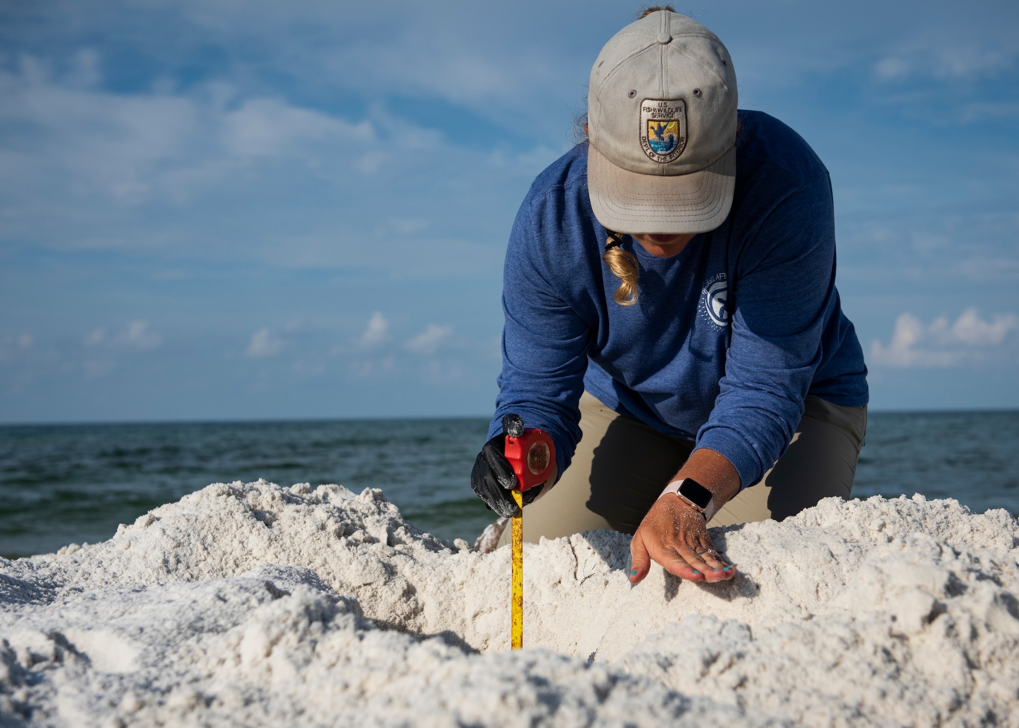 Danielle Bumgardner, U.S. Fish and Wildlife Services biologist, measures the depth of a sea turtle nest on the beach at Tyndall Air Force Base, Florida, June 5, 2019.