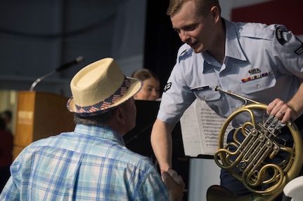 Airman 1st Class Derek Akers, a French horn player with the U.S. Air Force Heritage Winds, shakes hands with an audience member after a show June 6th, 2019, in Mount Pleasant, S.C.
