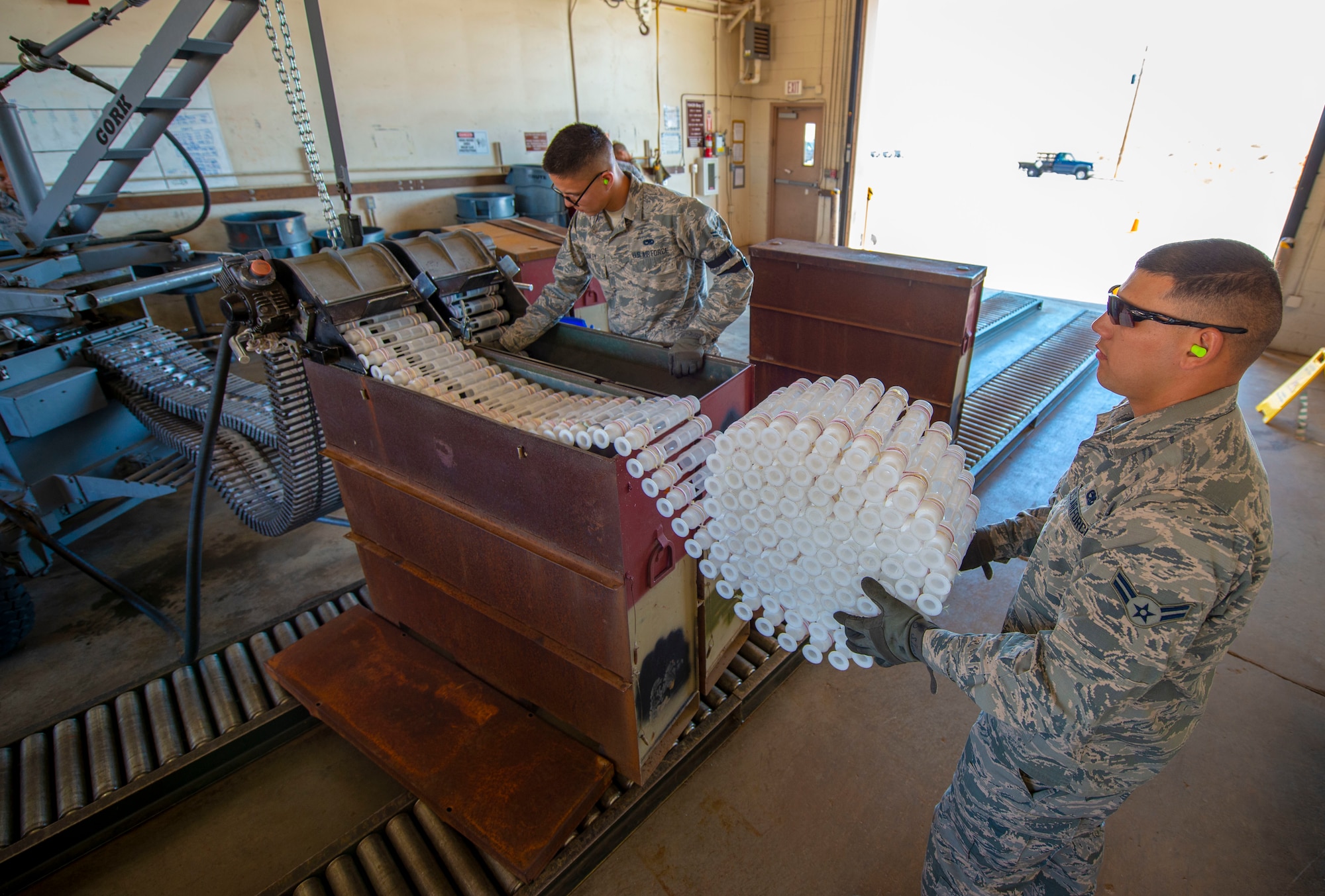 U.S. Air Force Airman 1st Class Stephen Luna, 57th Munitions Squadron (MUNS) small bombs crew member, wraps empty 30mm round holders at Nellis Air Force Base, Nev., June 4, 2019. Luna works in the small bombs section of MUNS where he processes and accounts for all small ammunition used and unused. (U.S. Air Force photo by Staff Sgt. Tabatha McCarthy)