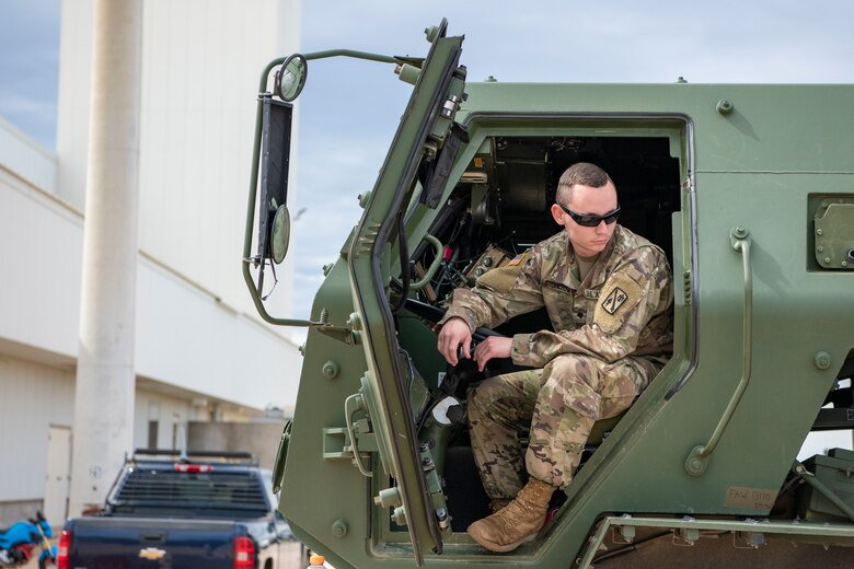 An Oklahoma Army National Guard Soldier prepares to load personnel and three High-Mobility Artillery Rocket Systems (HIMARS) into a C-17 Globemaster III, June 3, 2019, at Altus Air Force Base, Okla. During the joint-exercise, the troops worked with the 58th Airlift Squadron to simulate a deployed emergency scenario that tested the capabilities of how quickly they can mobilize. (U.S. Air Force photo by Airman 1st Class Breanna Klemm)