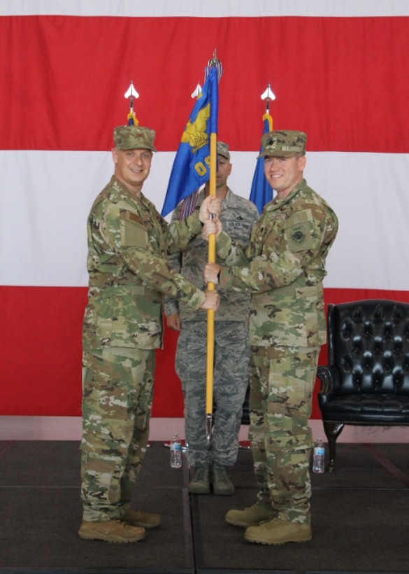 Lt. Col. Brad Dvorak accepts command of the 552nd Operations Support Squadron in an official ceremony on June 7.  The change of command was presided over by Col. Joshua Conine, commander of the 552nd Operations Group while Master Sgt. Nathan Davis, the First Sergeant of the 552nd OSS, served as the guidon bearer. (U.S. Air Force photo/2nd Lt. Ashlyn K. Paulson).