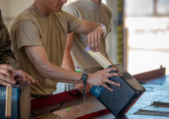 U.S. Air Force Airman 1st Class Mattias Jacobson, 57th Munitions Squadron line crew member, loads a mod so they can be delivered to the respected unit in need of the flares at Nellis Air Force Base, Nev., June 4, 2019. While handling flare mods, line delivery Airmen wear a band that grounds their hands to a copper wire to ensure no electric spark set off the flares. (U.S. Air Force photo by Staff Sgt. Tabatha McCarthy)