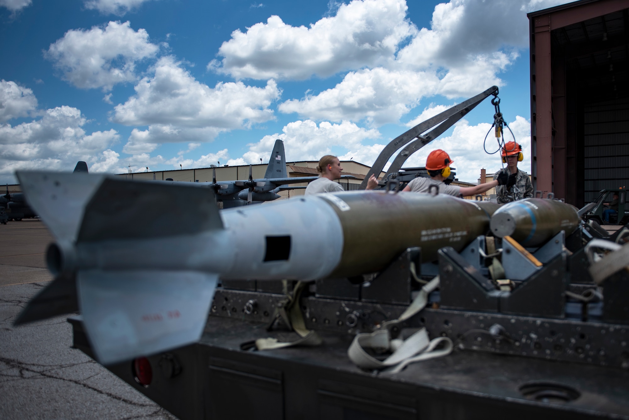 363rd Training Squadron munitions apprentice course students attach a Mark 82 training bomb to an MJ-1 ammunition loader while their instructor, left, supervises at Sheppard Air Force Base, Texas, June 7, 2019. The students actually built the bombs before and are now performing a crossload, which moves the bombs from one trailer to another. A crossload is performed when a trailer is either scheduled for maintenance or due to mission requirements must be moved. (U.S. Air Force phoot by Airman 1st Class Pedro Tenorio)