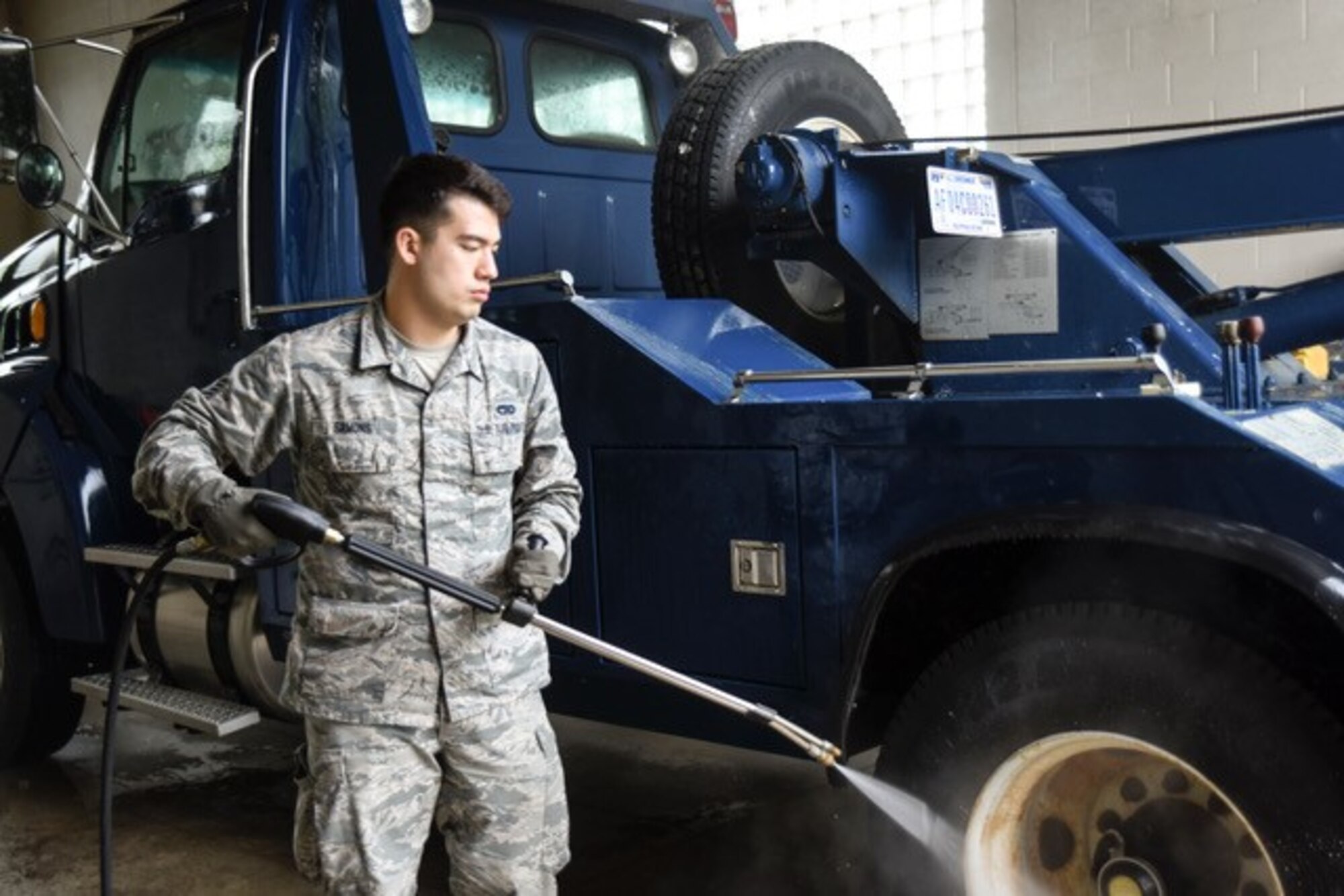 A man wearing the Airman Battle Uniform washes a truck.