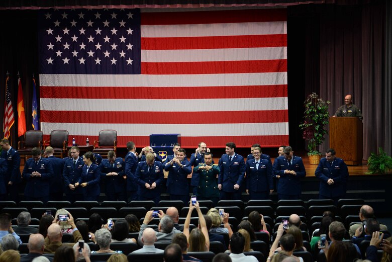 A group of pilots from Specialized Undergraduate Pilot Training Class 19-10/16 break their silver wings in half May 31, 2019, on Columbus Air Force Base, Miss. The tradition of breaking the first issued pair of wings brings good luck as one half is kept by the pilot while the other is given to a loved one. (U.S. Air Force photo by Airman 1st Class Jake Jacobsen)